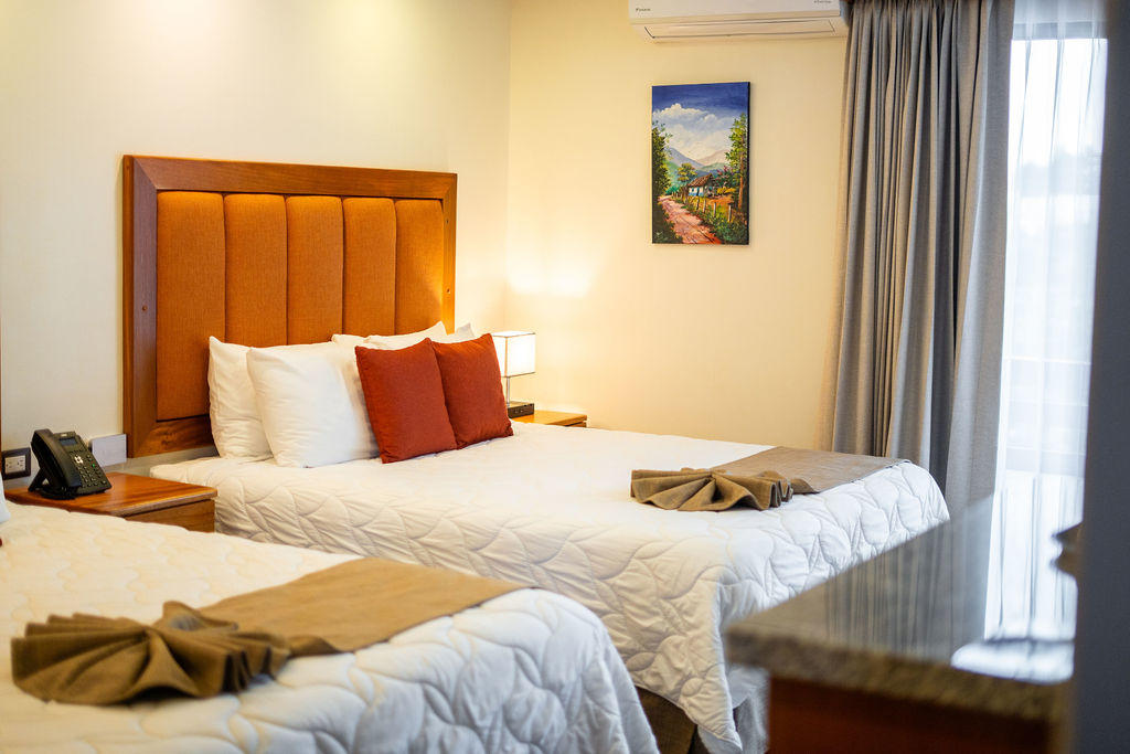 Bed detail in Quetzal Room featuring two queen beds with comfortable bedding at Hotel & Spa Poco a Poco, Monteverde