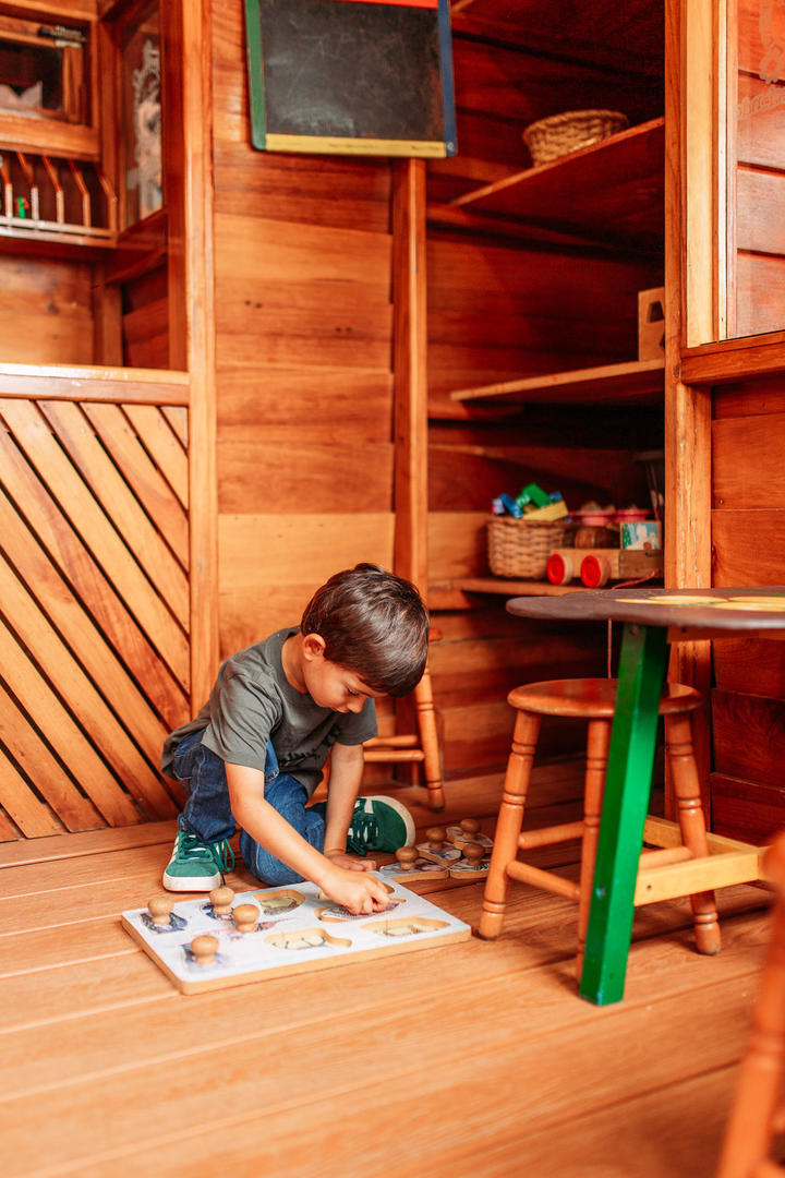 Child painting inside the wooden kids house at Hotel & Spa Poco a Poco, Monteverde