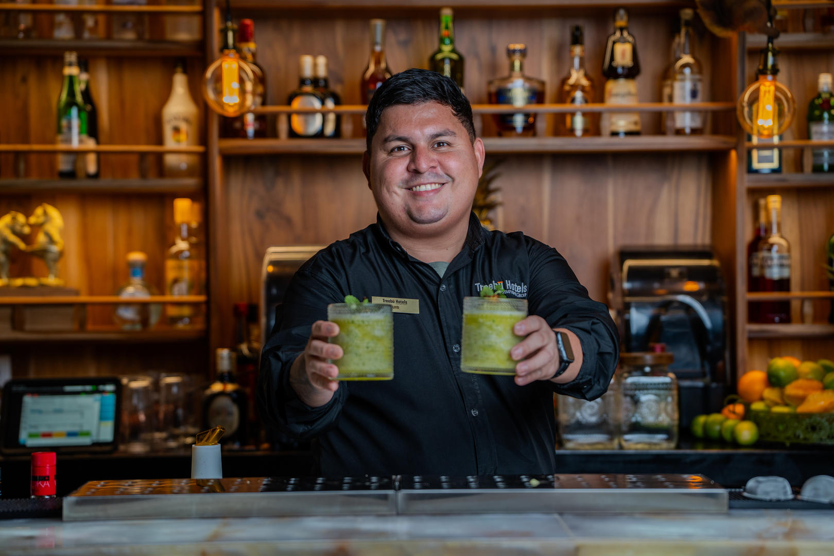 Bartender smiling while presenting two freshly made mojitos at Hotel & Spa Poco a Poco, Monteverde