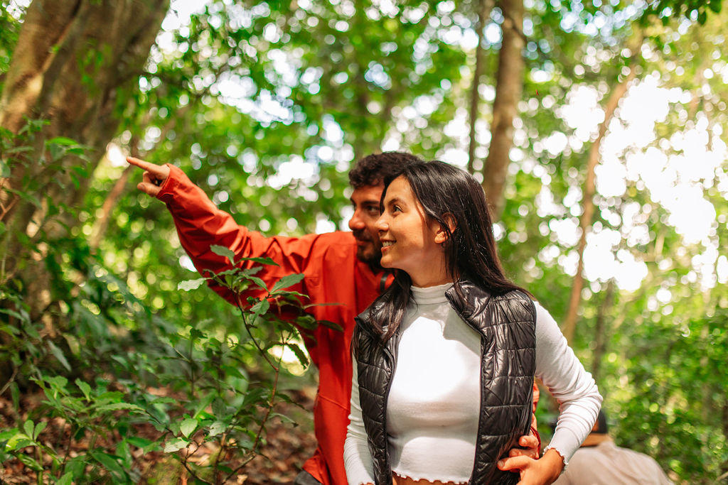 Man holding his partner by the waist while pointing at nature surroundings at Hotel & Spa Poco a Poco, Monteverde