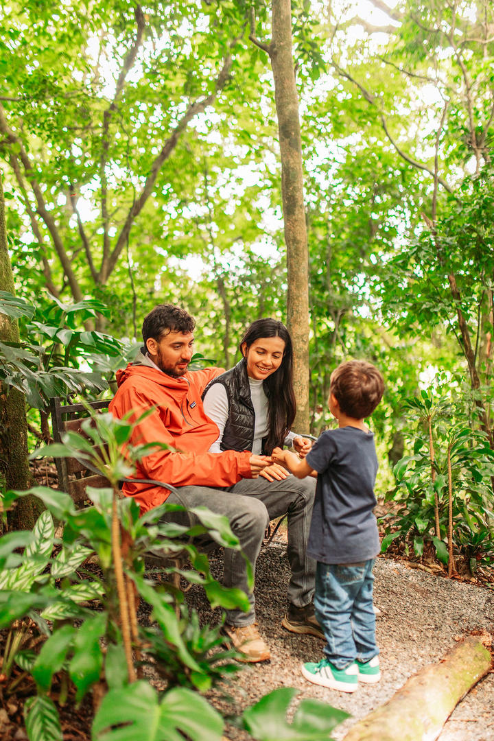 Family relaxing on a bench along a nature trail at Hotel & Spa Poco a Poco, Monteverde