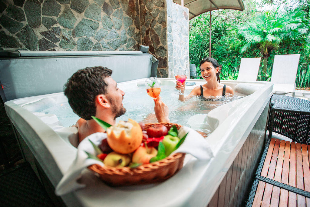 Couple toasting in the private jacuzzi of Garden Superior with Jacuzzi at Hotel & Spa Poco a Poco, Monteverde
