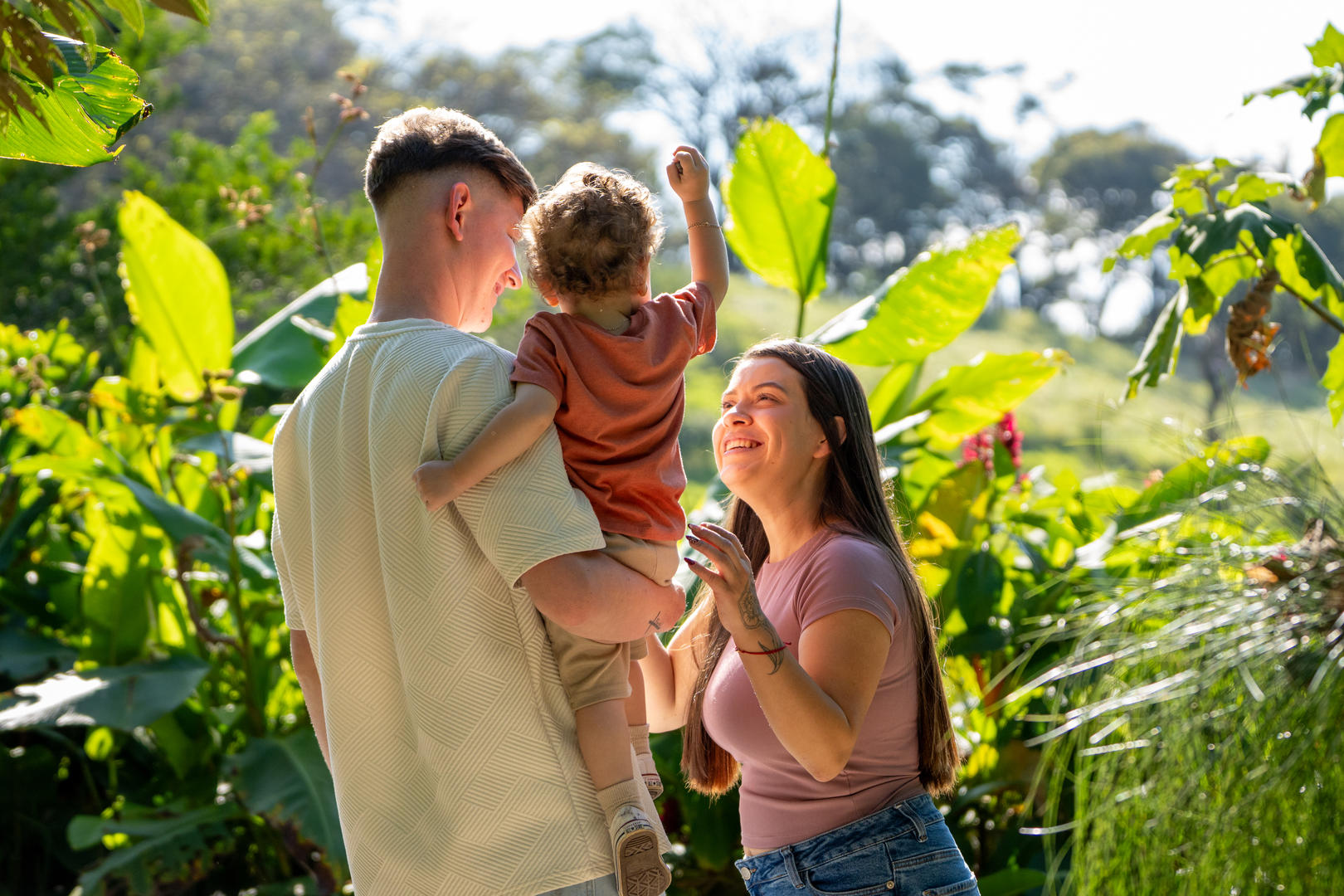 Young couple holding a baby while walking along the hotel’s nature trails at Hotel & Spa Poco a Poco, Monteverde