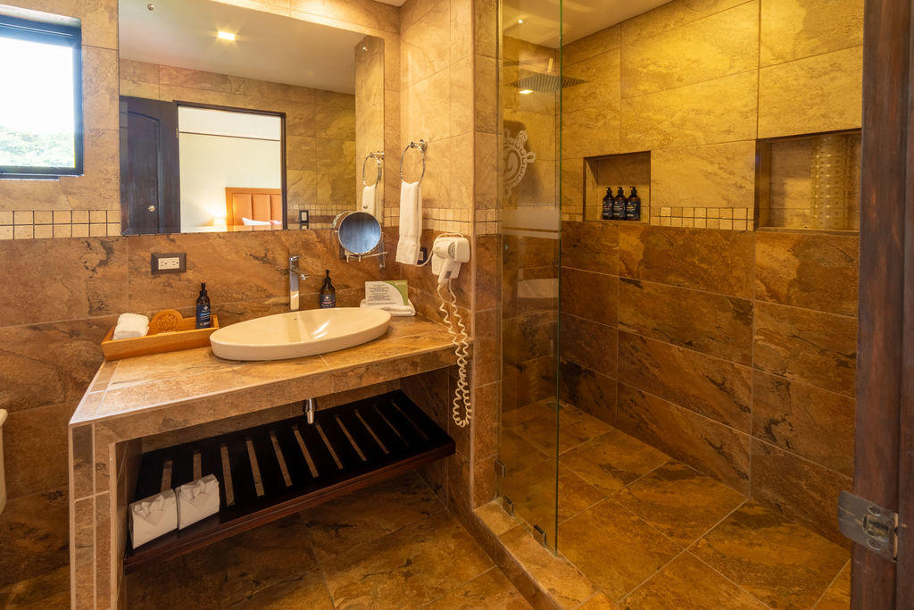 Luxury amber toned bathroom in Quetzal Room with elegant finishes at Hotel & Spa Poco a Poco, Monteverde