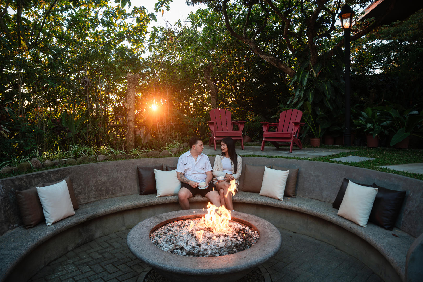 Couple sitting by the fire pit at sunset at Hotel & Spa Poco a Poco, Monteverde