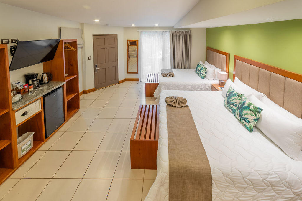 Wide view of Garden Family Room with beds and a window overlooking the exterior at Hotel & Spa Poco a Poco, Monteverde