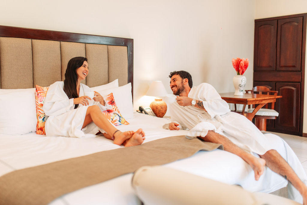 Relaxing couple in robes on the bed in Forest Deluxe with Jacuzzi at Hotel & Spa Poco a Poco, Monteverde