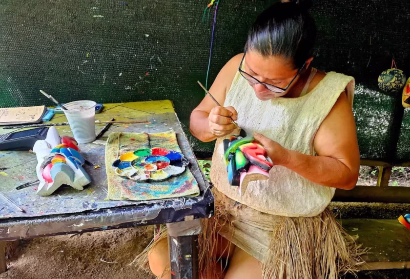Maleku woman painting a traditional mask during a cultural demonstration included in an ATV tour in La Fortuna, Costa Rica