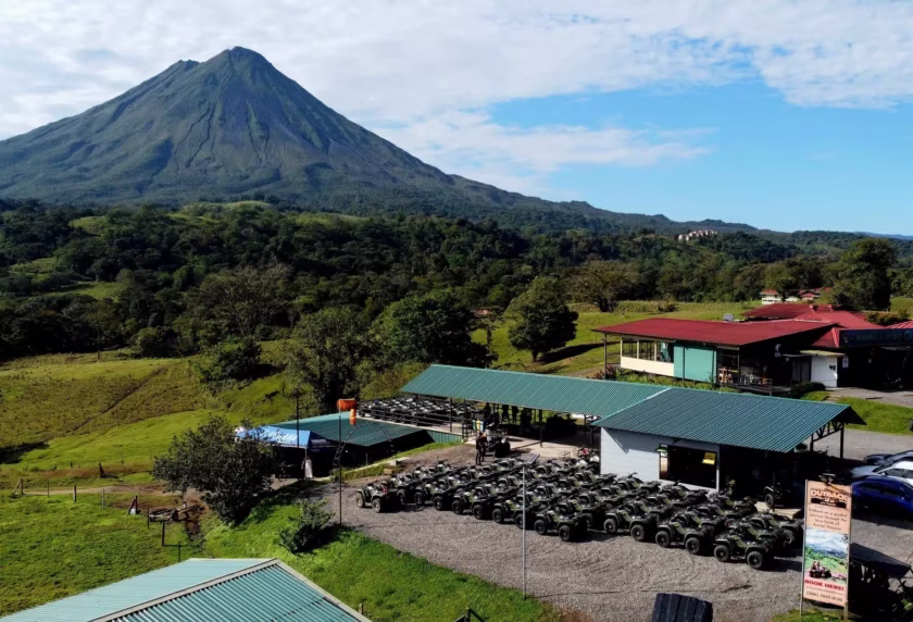 Aerial view of the tour base with a large fleet of ATVs and UTVs and Arenal Volcano in the background in La Fortuna, Costa Rica