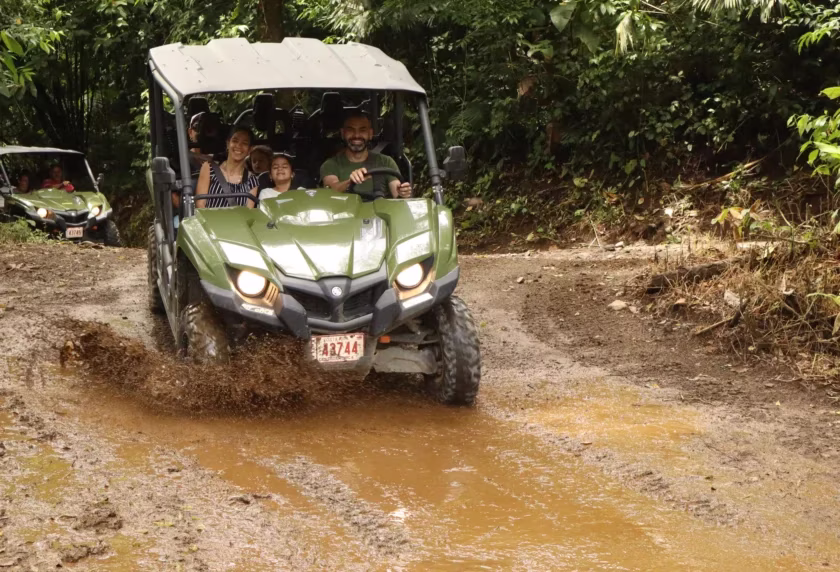 Happy family smiling inside a side by side UTV before entering a muddy section during a tour in La Fortuna, Costa Rica
