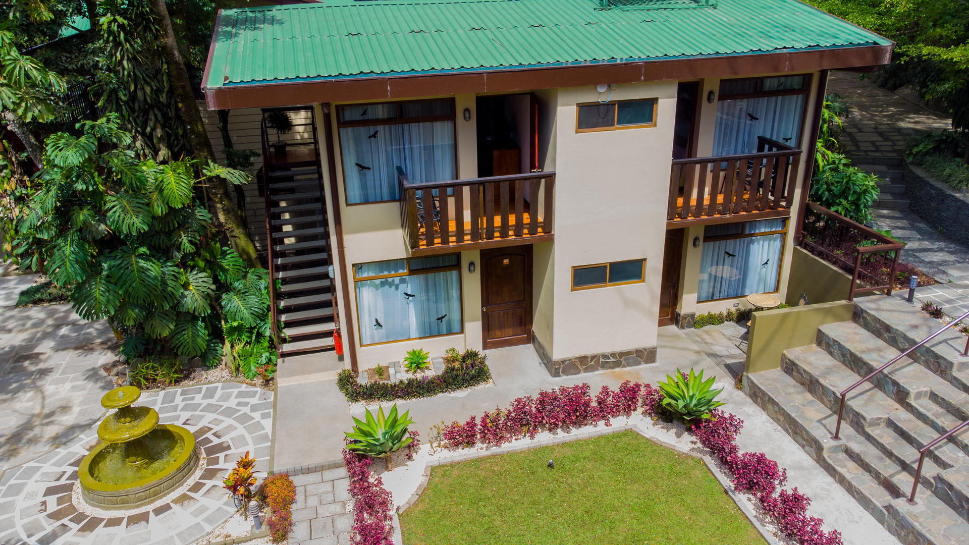 Aerial view of two story guest room buildings surrounded by gardens and a central fountain at Monteverde Country Lodge, Monteverde, Costa Rica