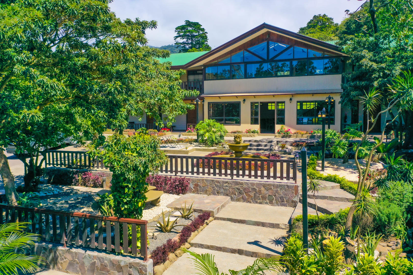 Wide front view of the main building surrounded by gardens at Monteverde Country Lodge, Monteverde, Costa Rica