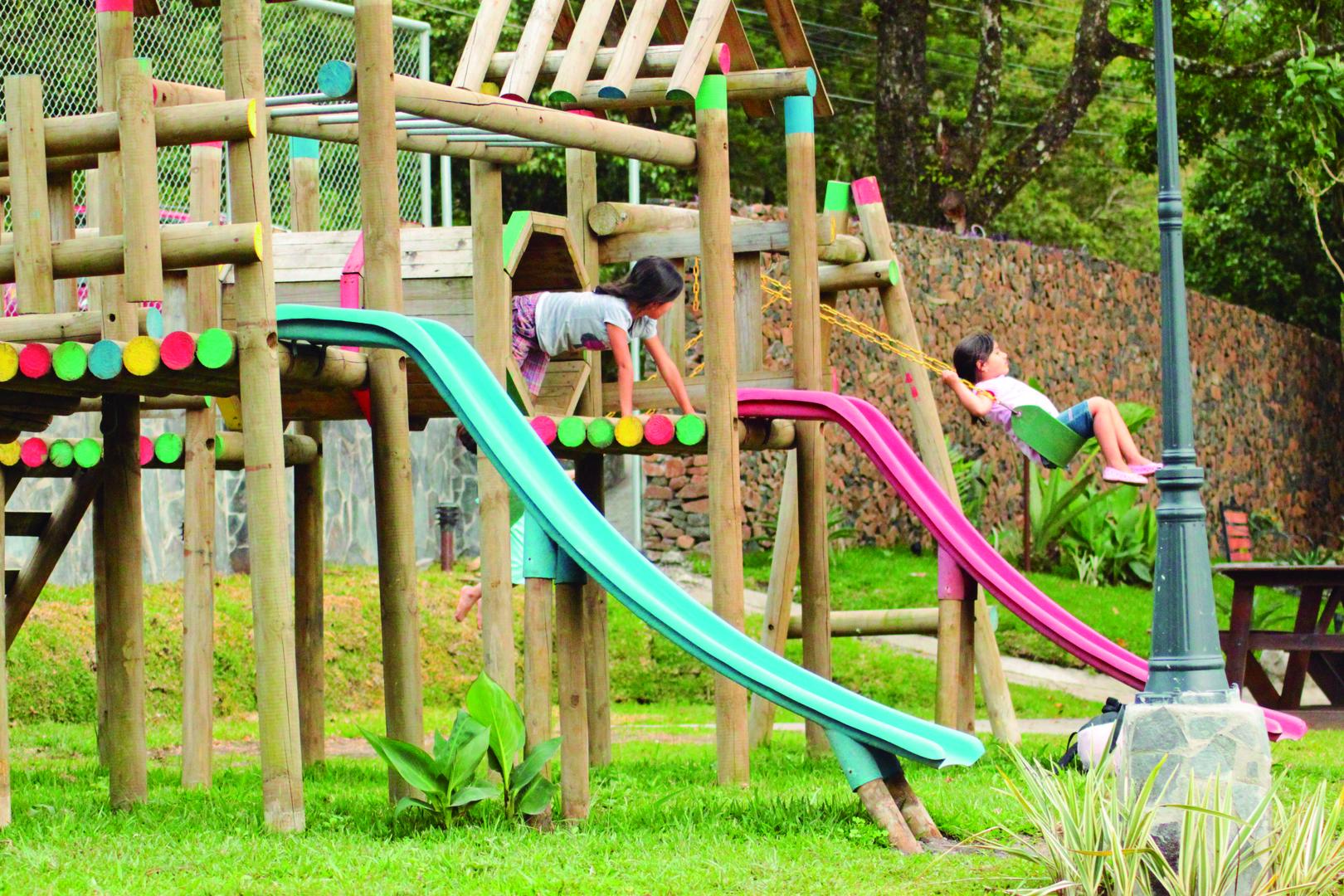 Children playing in the playground located in a landscaped garden at Monteverde Country Lodge, Monteverde, Costa Rica