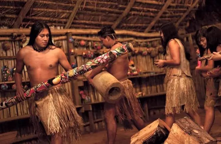 Maleku Indigenous group performing a cultural demonstration inside a traditional hut in La Fortuna, Costa Rica