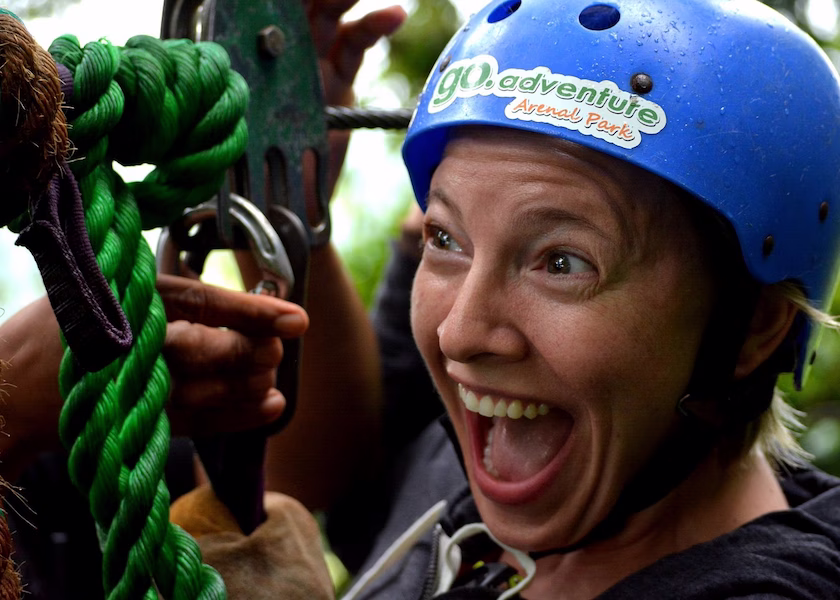 Close up of a woman wearing a helmet, excited before ziplining