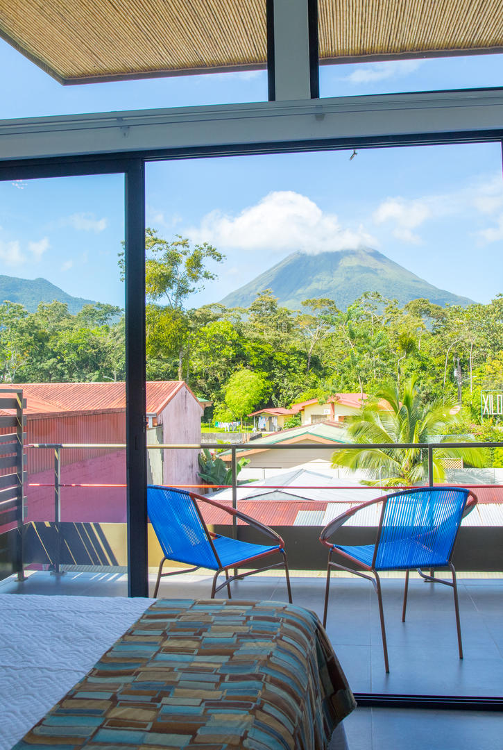 Superior room exterior view of Arenal Volcano with smoke at the summit at La Fortuna Lodge, La Fortuna, Costa Rica
