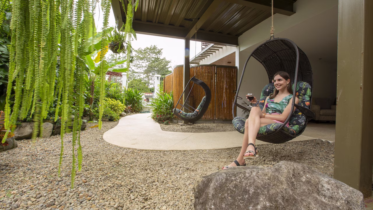 Woman resting on a hammock chair in the upper level rooms at La Fortuna Lodge, La Fortuna, Costa Rica