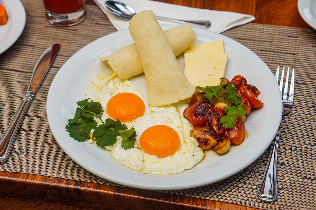 Breakfast plate with eggs, cooked tomatoes, cheese, and tortilla at La Fortuna Lodge, La Fortuna, Costa Rica