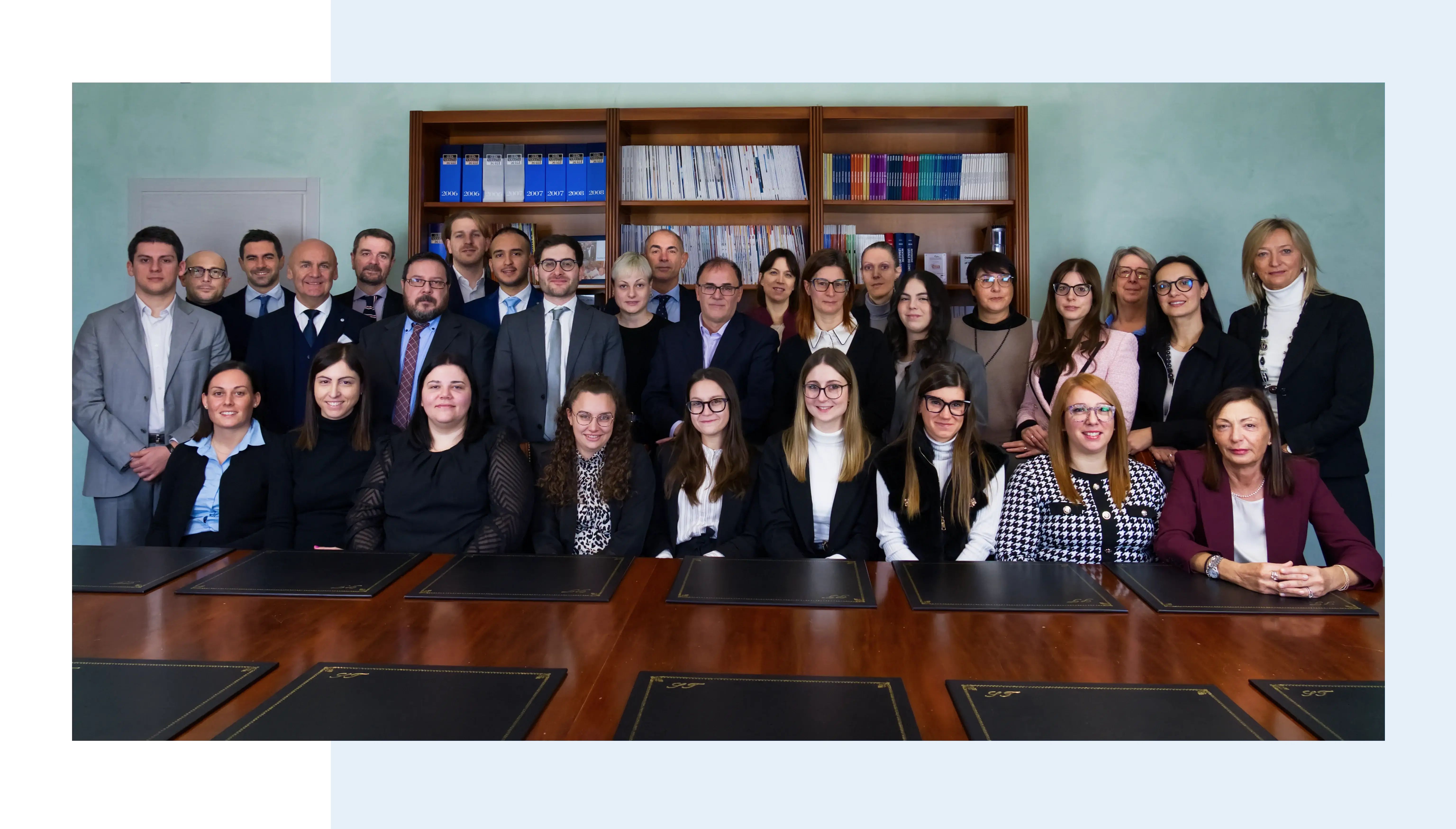 Un gruppo di persone sorride alla fotocamera in un ufficio.