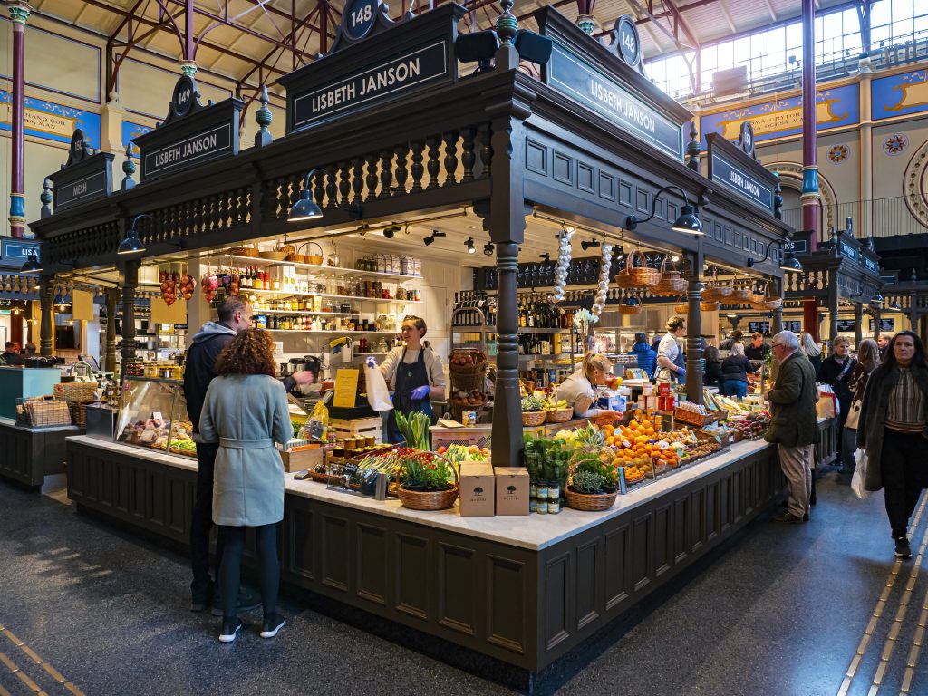 Interior del mercado Östermalms Saluhall de Estocolmo con sus puestos gastronómicos
