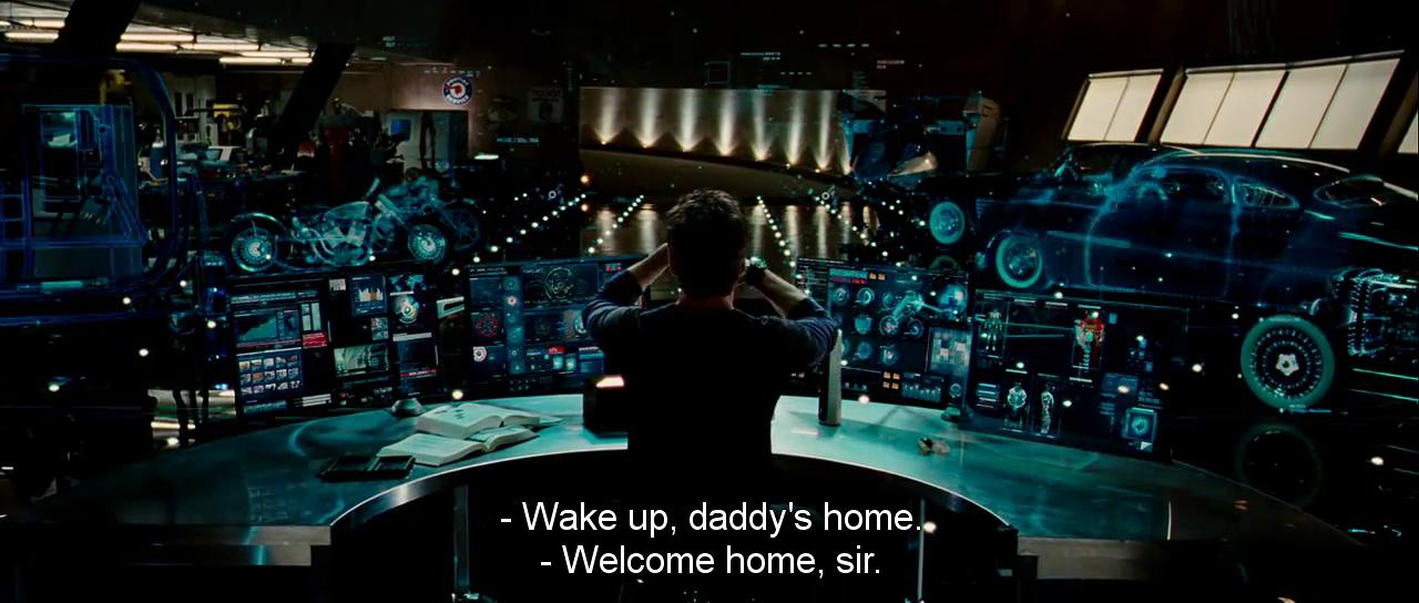 Tony Stark at his multi-monitor holographic workstation greeting J.A.R.V.I.S. in Iron Man