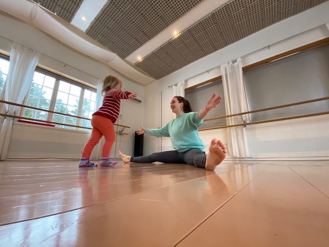 An image of a child and parent dancing together