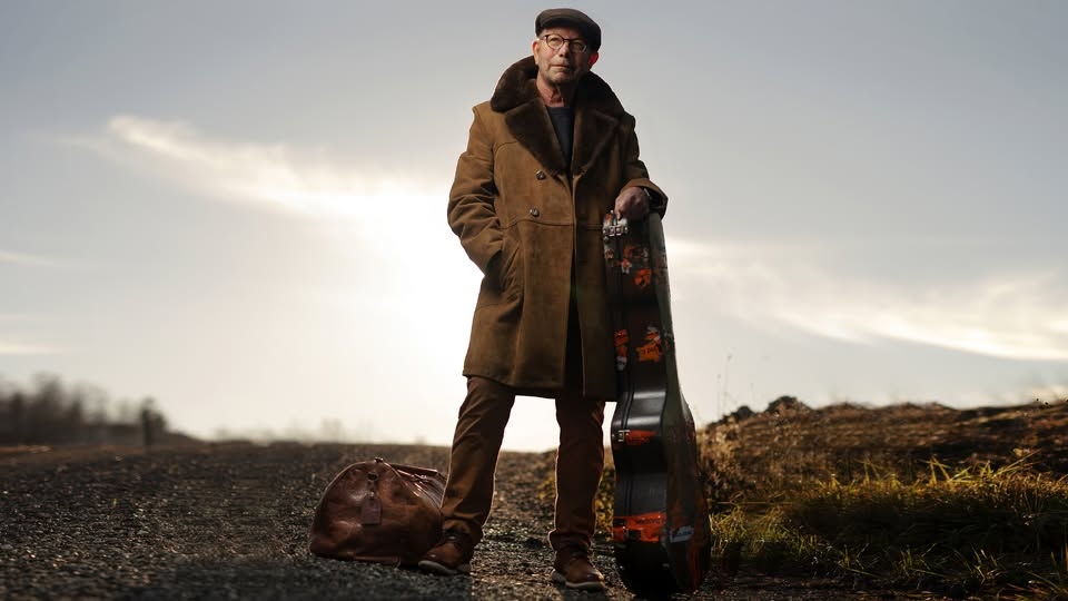 May be an image of 1 person, suitcase, overcoat and duffle coat