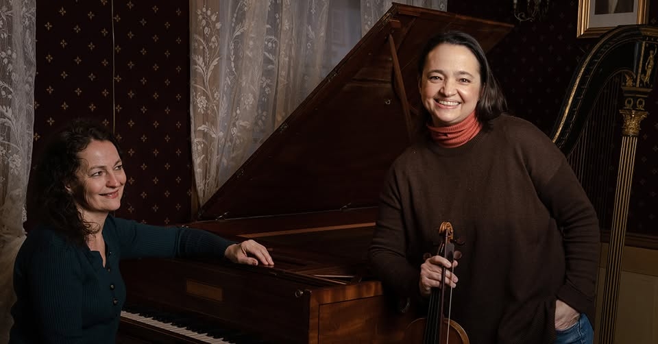An image of 2 people, piano and violin