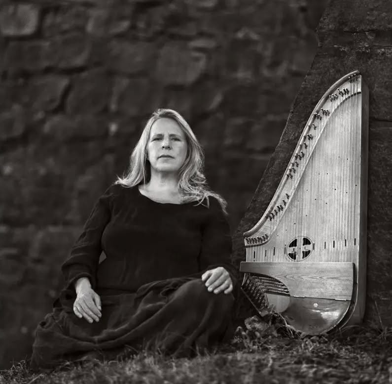 An image of harp and a woman