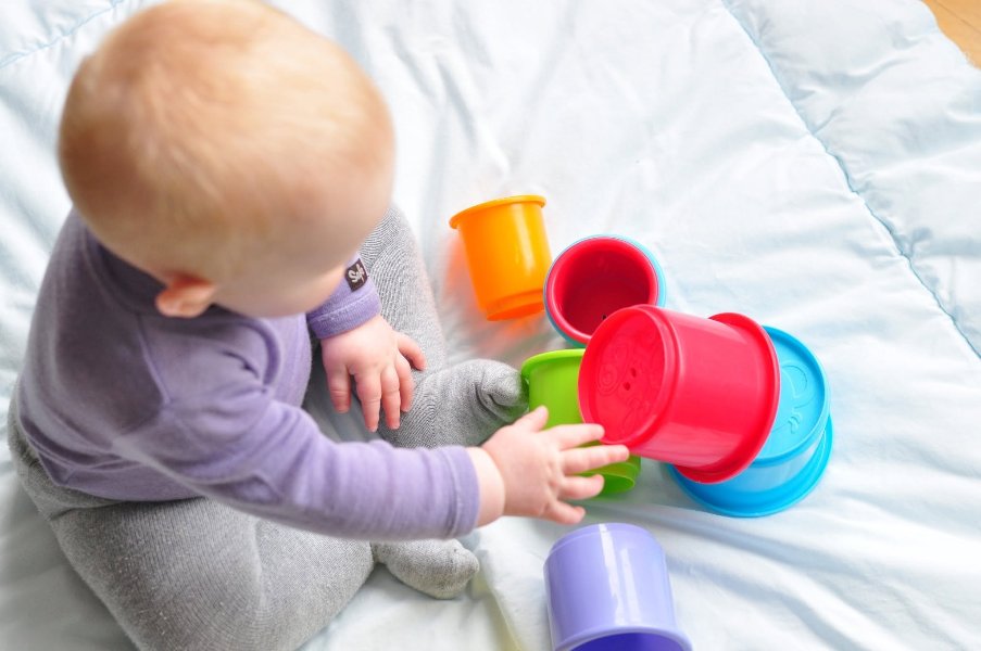 May be an image of baby, toy and text