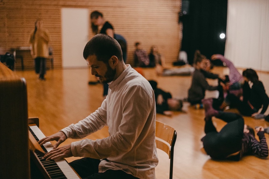 May be an image of a person playing piano, people dancing in the background