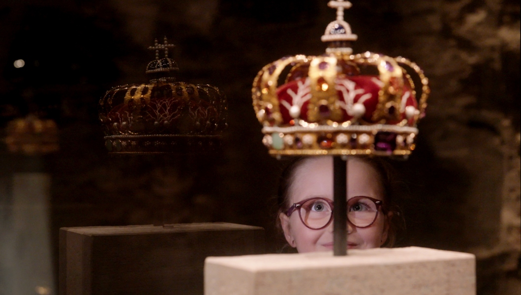 Jente som ser opp på den norske kongekronen