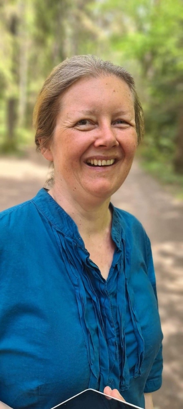 Ung, hvit kvinne, lysblond, smilende, i blå bluse