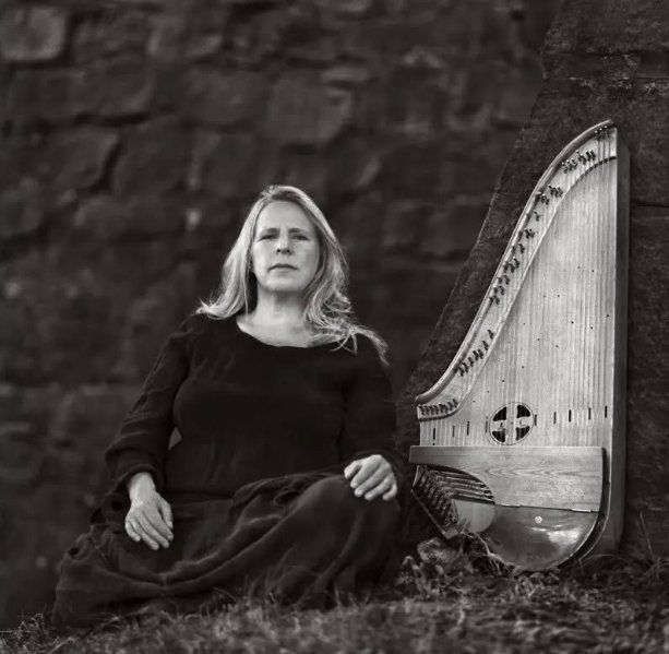An image of harp and a woman