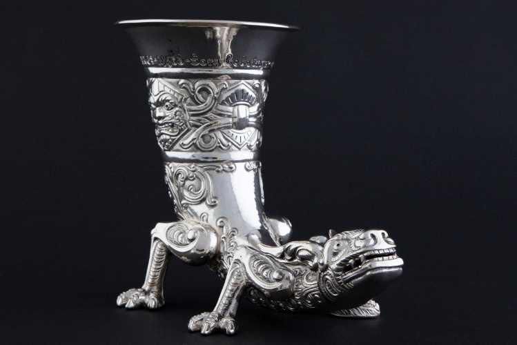 Drikkehorn i sølv med form som en drag, sort bakgrunn