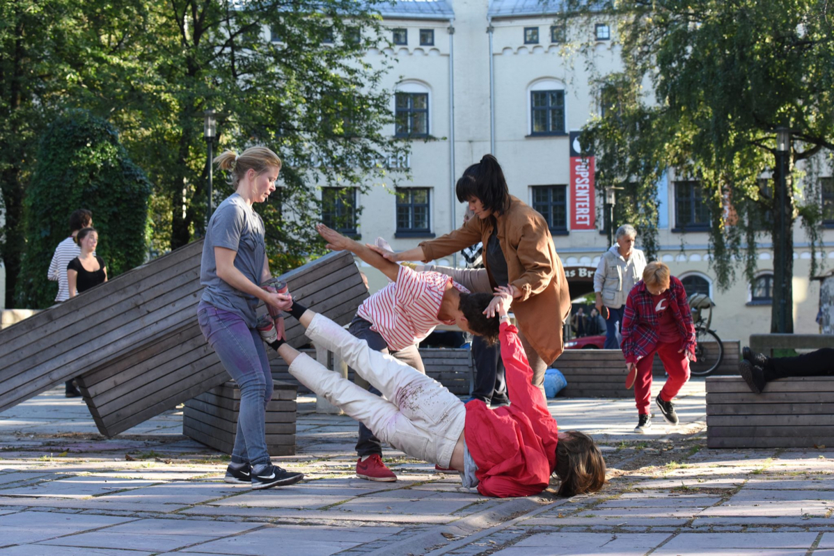 An image of 4 people  dancing on the street