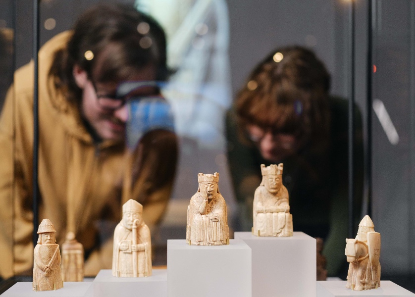 To mennesker ser på Lewisbrikker i utstillingen