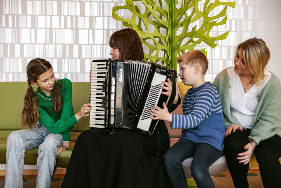 Image of 4 people, child and accordion