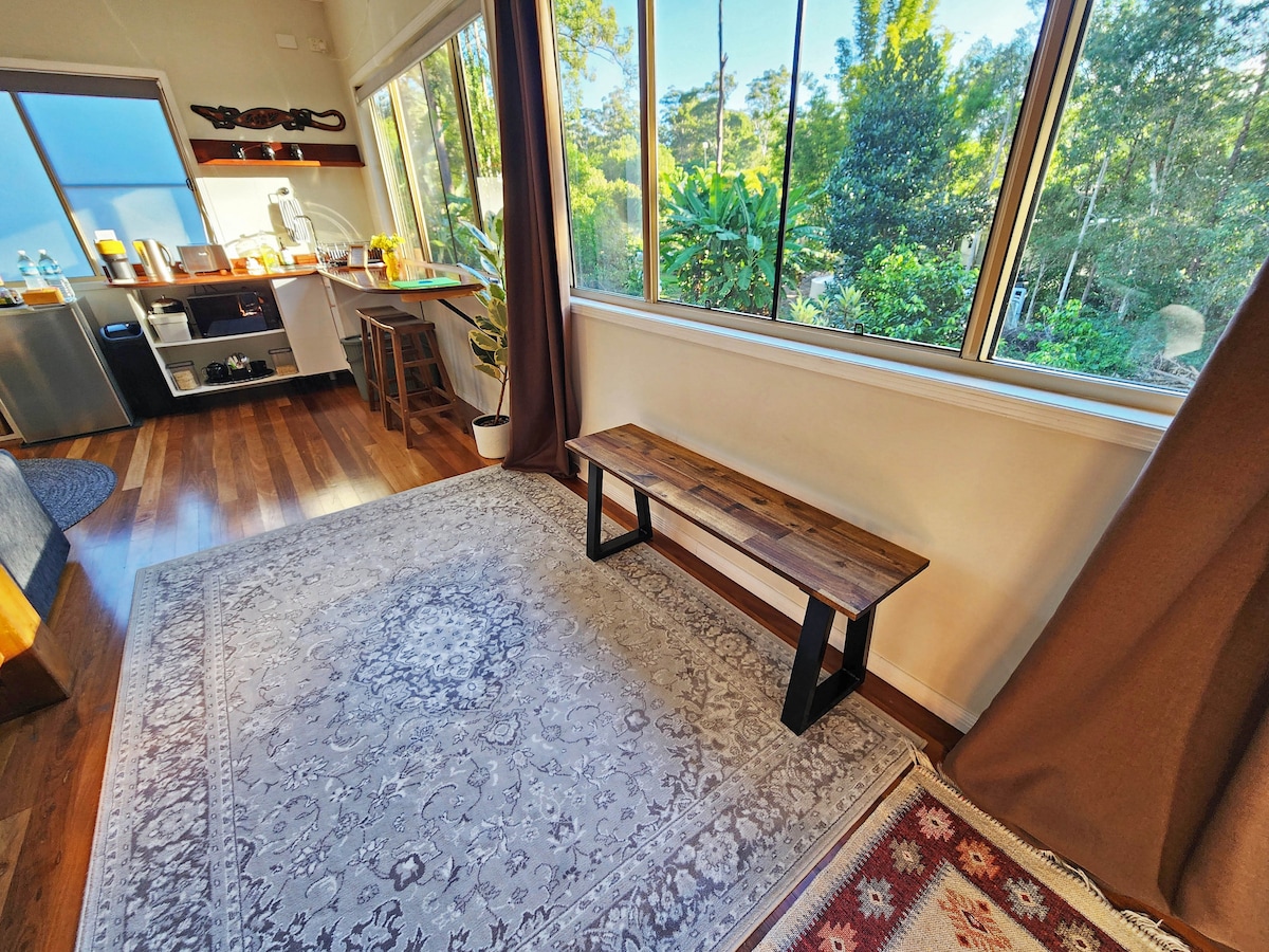 Calm sun-filled studio with leafy views and cozy vibes - basically nature, but with Wi-Fi and a comfy bed.