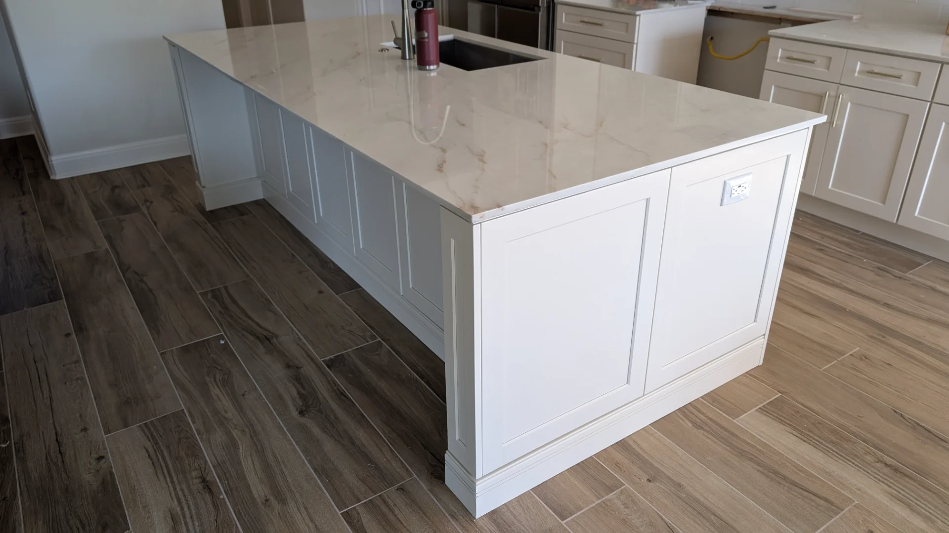 Transitional kitchen design in a Driftwood, Texas home featuring custom off-white cabinetry with gold hardware, a curved range hood, and white marble-look quartz countertops, serving homeowners in Austin and the Texas Hill Country. - Detail 4