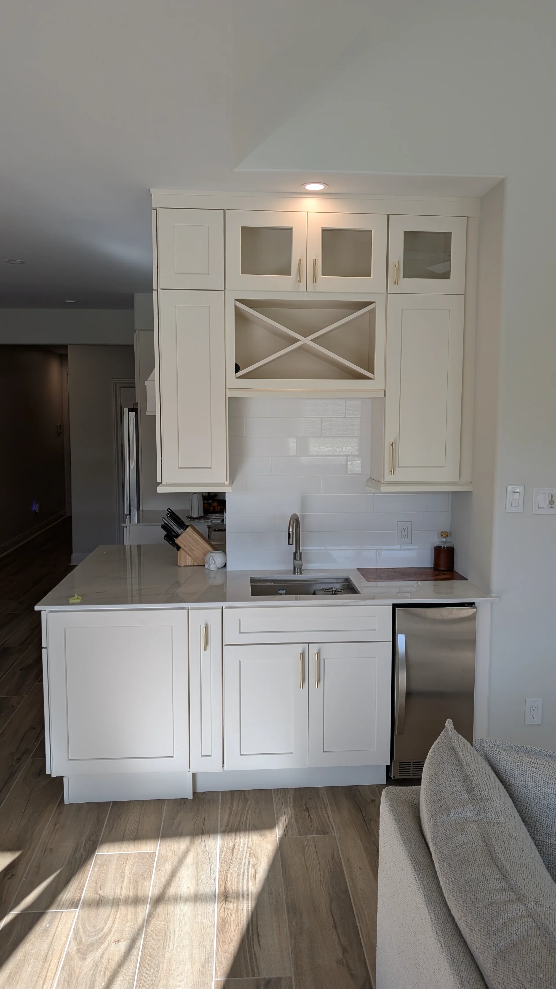 Transitional kitchen design in a Driftwood, Texas home featuring custom off-white cabinetry with gold hardware, a curved range hood, and white marble-look quartz countertops, serving homeowners in Austin and the Texas Hill Country. - Detail 2