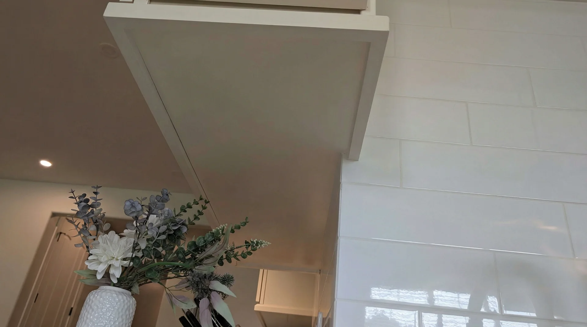 Transitional kitchen design in a Driftwood, Texas home featuring custom off-white cabinetry with gold hardware, a curved range hood, and white marble-look quartz countertops, serving homeowners in Austin and the Texas Hill Country. - Detail 8