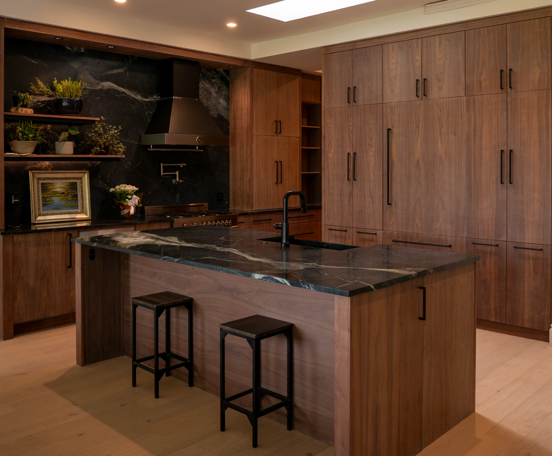 Modern grain-matched walnut kitchen in Austin, West Lake Hills, featuring a green soapstone backsplash, stainless steel range, and minimalist island cabinetry. - Detail 9