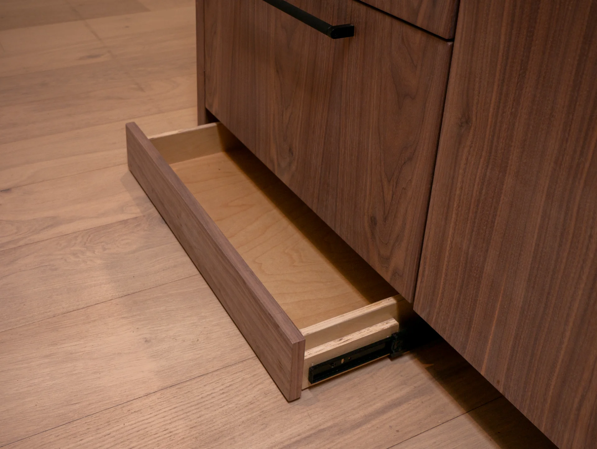 Modern grain-matched walnut kitchen in Austin, West Lake Hills, featuring a green soapstone backsplash, stainless steel range, and minimalist island cabinetry. - Detail 2