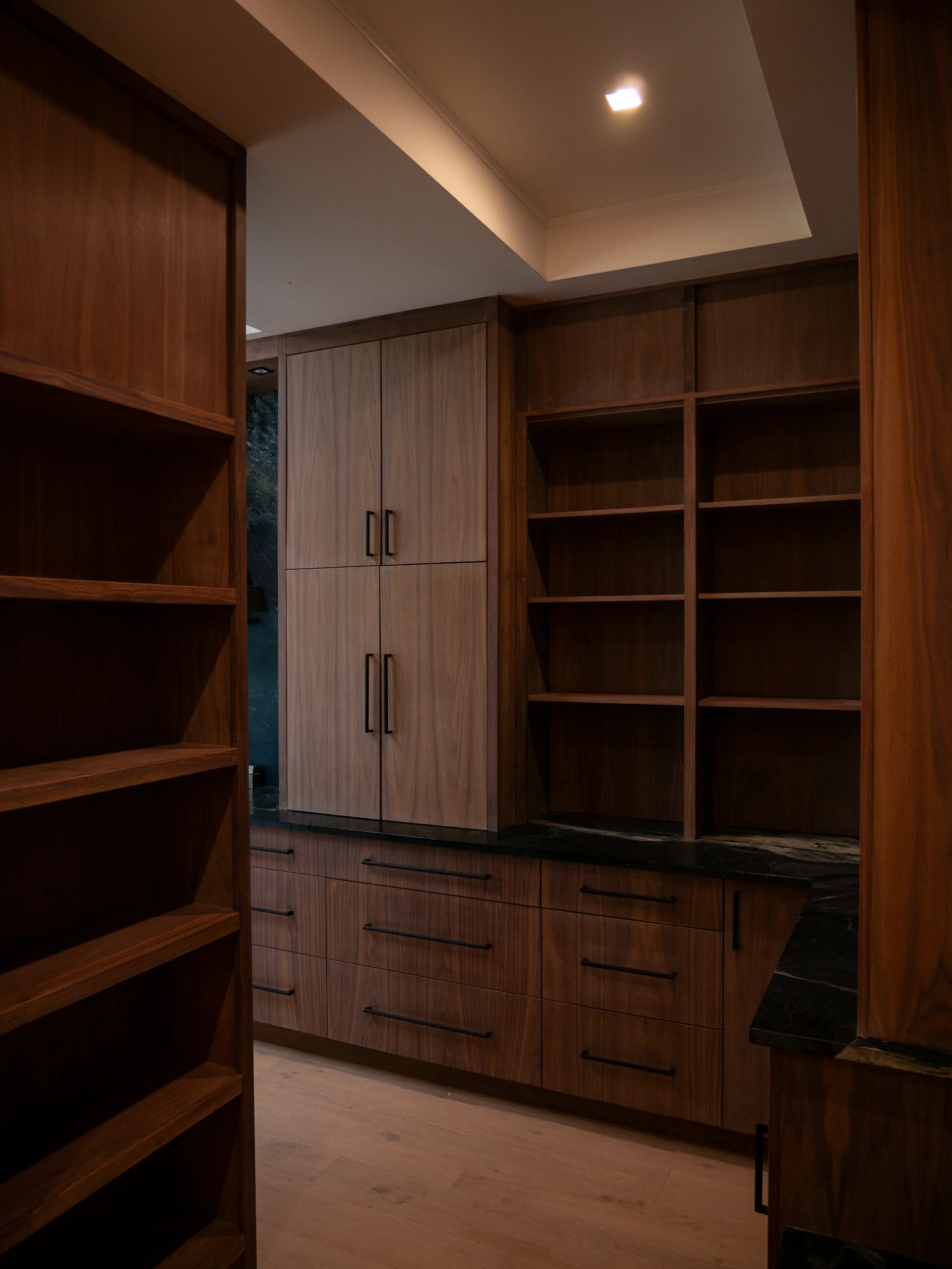 Modern grain-matched walnut kitchen in Austin, West Lake Hills, featuring a green soapstone backsplash, stainless steel range, and minimalist island cabinetry. - Detail 5