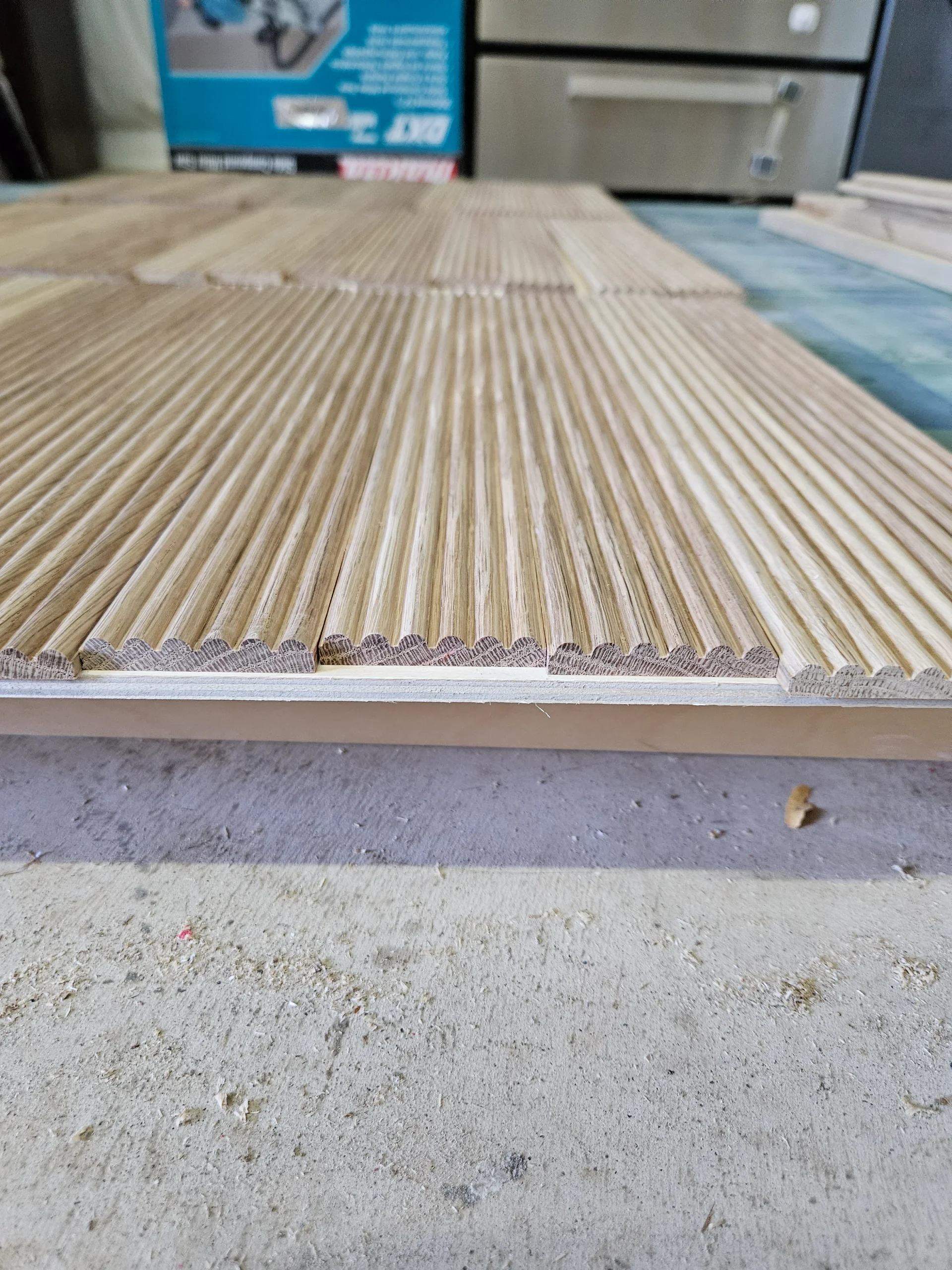 A custom built-in white oak cabinet with modern slatted door panels is set against a white wall in an Austin home. Above the credenza hangs a large mountain landscape painting, complemented by light-toned wood flooring in this West Lake Hills residence. - Detail 2