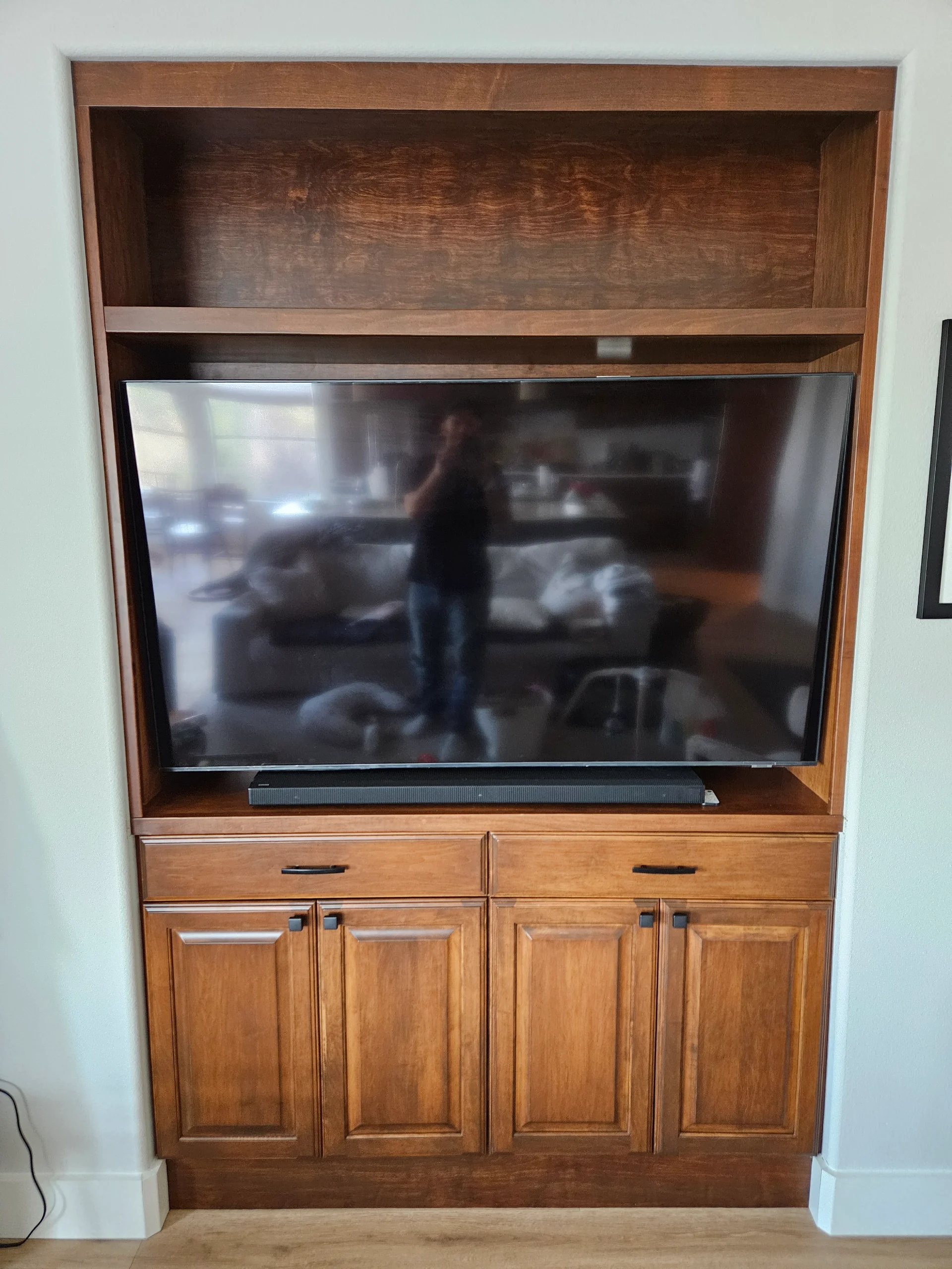 Sophisticated home theater in West Lake Hills, Austin, featuring a large custom black built-in entertainment center with marble countertops, an integrated wine fridge, and classic movie posters for Jaws and Pulp Fiction. - Detail 2