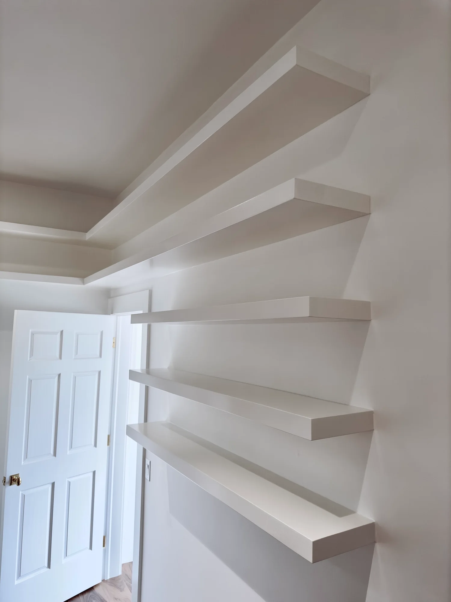 Modern custom home interior in West Lake Hills, Austin, featuring elegant hardwood floors, built-in floating shelves, a bright skylight, and a white ceiling fan. - Detail 5