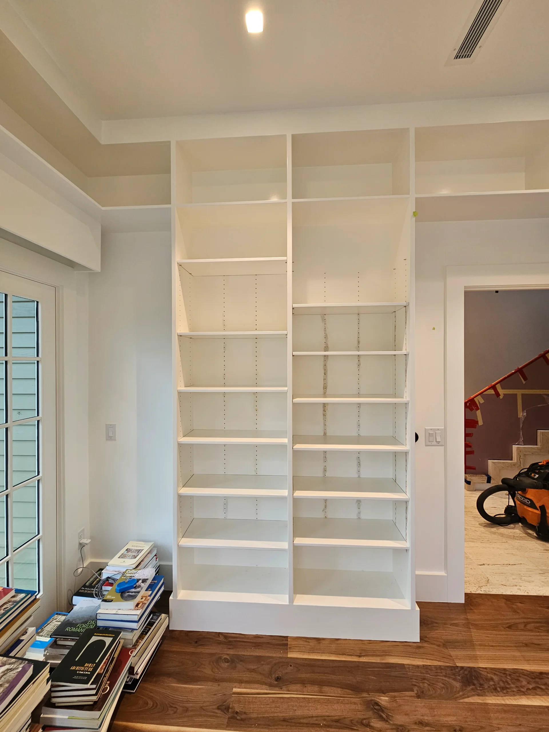 Modern custom home interior in West Lake Hills, Austin, featuring elegant hardwood floors, built-in floating shelves, a bright skylight, and a white ceiling fan. - Detail 4