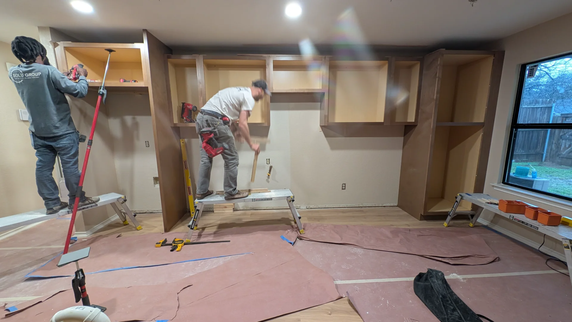 A newly completed modern kitchen remodel in Austin, Texas, featuring custom wood shaker cabinets, a large white quartz waterfall island with a sink, and stainless steel appliances. - Detail 2